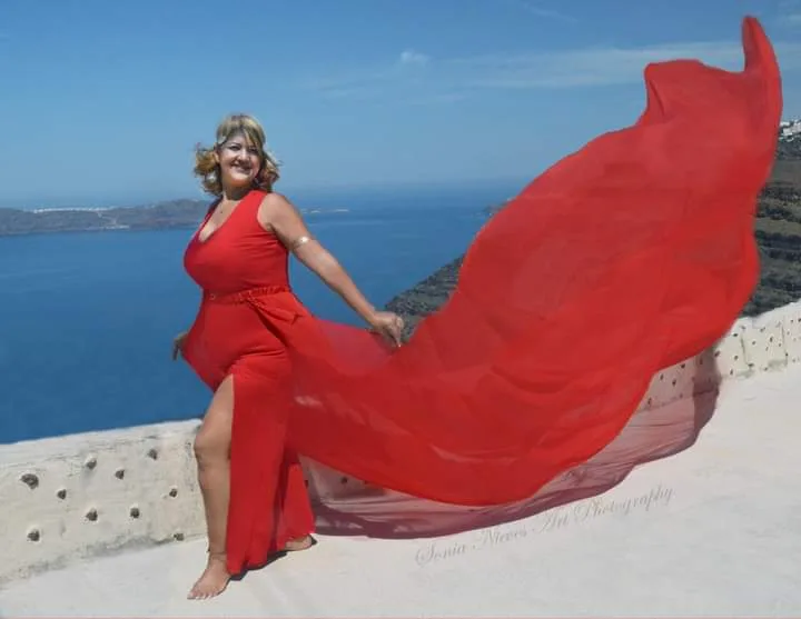 Una de nuestras viajeras en su vestido  volador rojo en Santorini.
